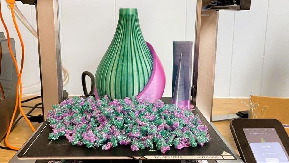 A 3D printed vase sitting amidst a bunch of waste material.