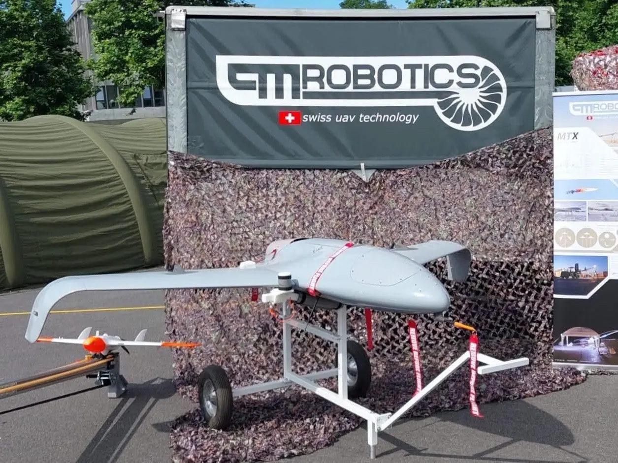 3d printed drone outdoors in front of a banner that says PMRobotics