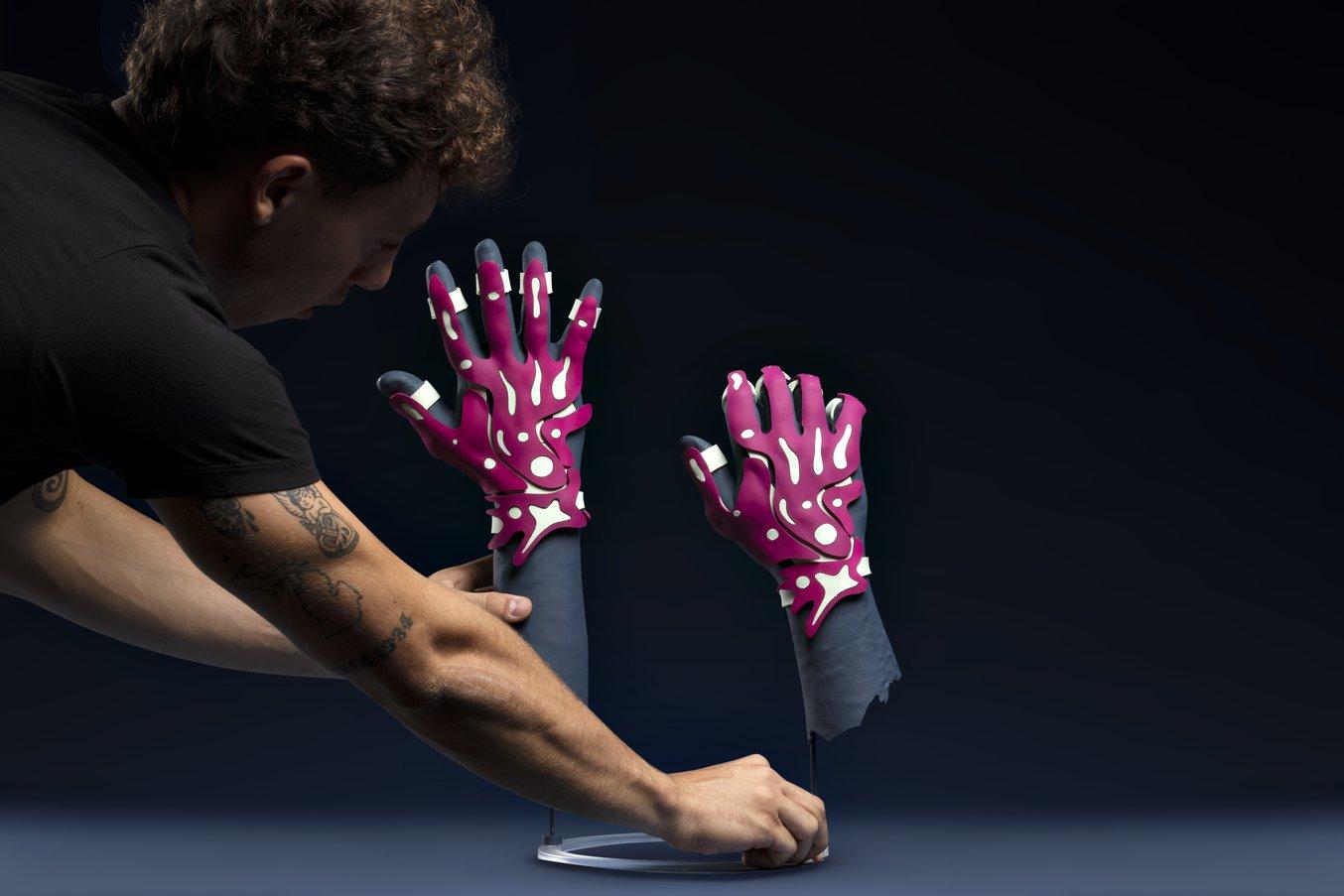 Una persona sostiene un manichino con due guanti stampati in 3D