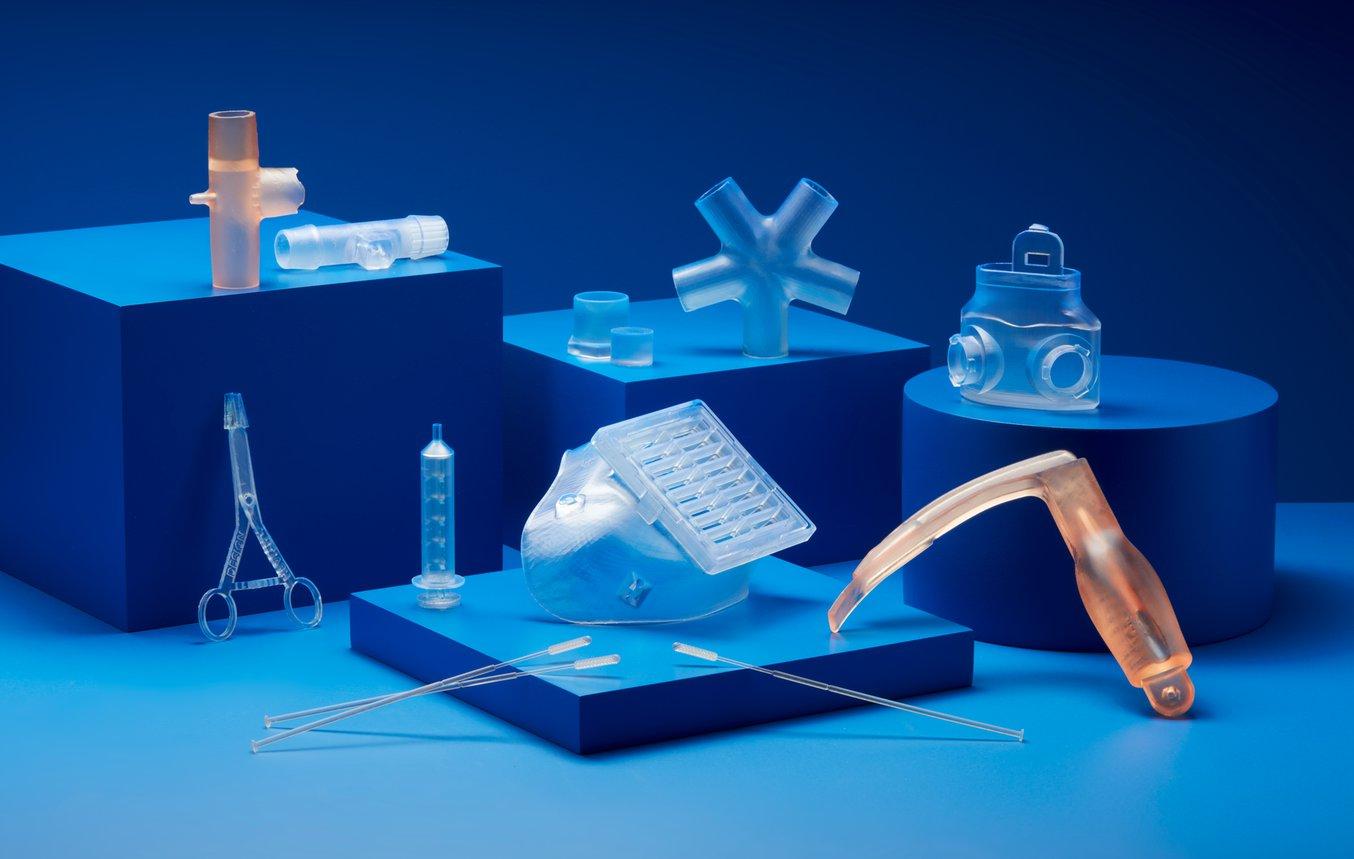 Various 3D printed medical parts laid out with a blue background