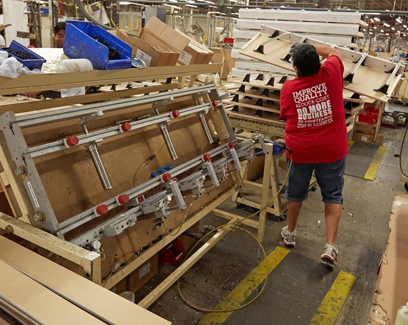 Workers at an assembly fixture at Ashley Furniture