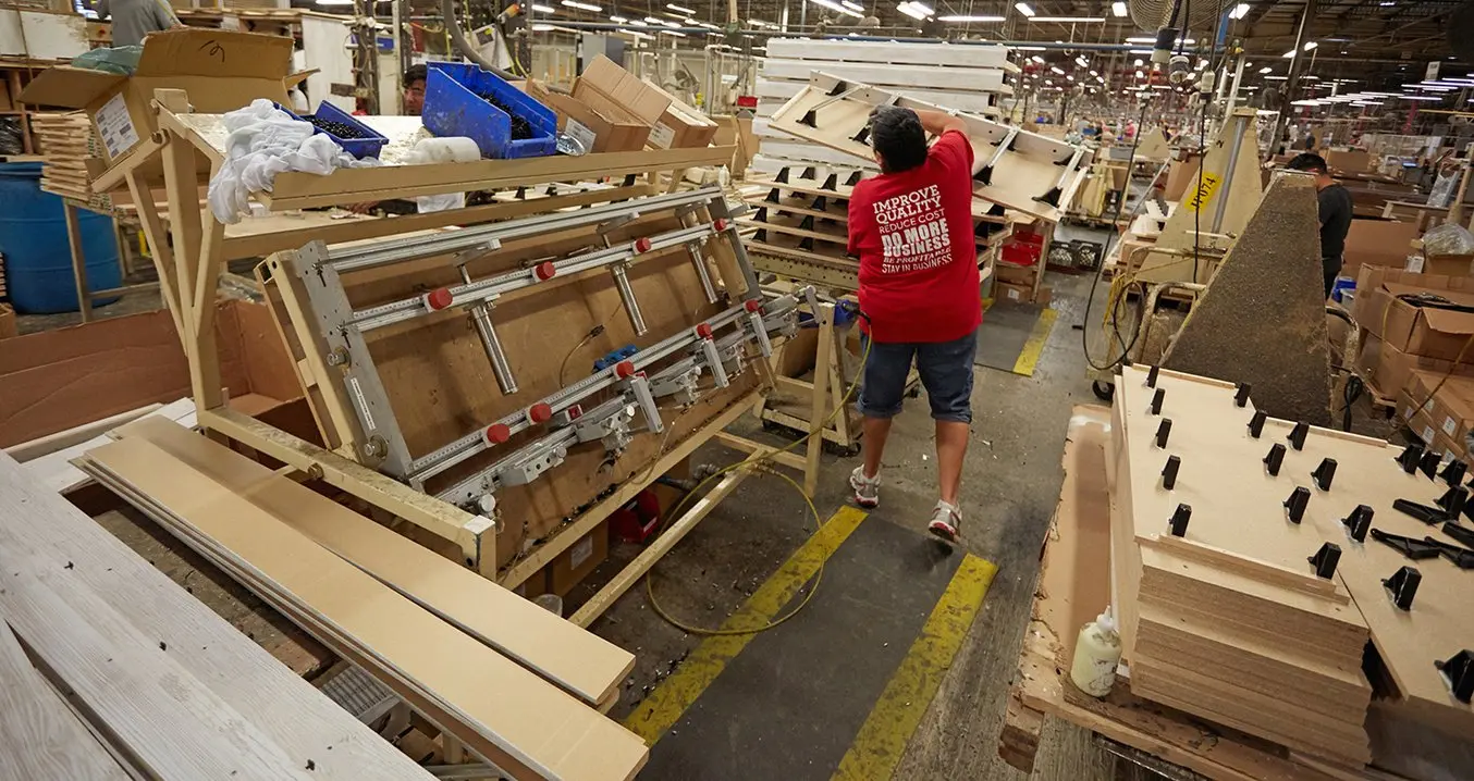 Workers at an assembly fixture at Ashley Furniture