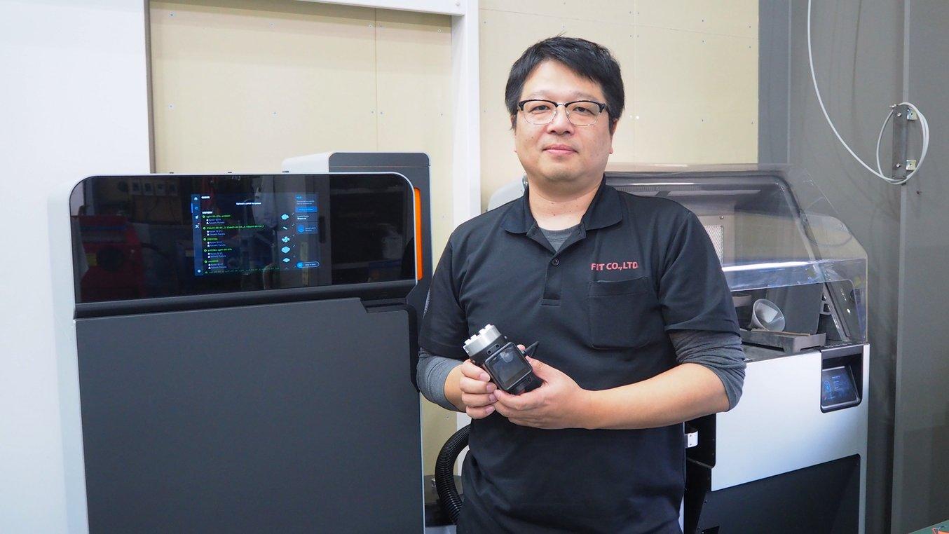 タッチスクリーンUIを搭載したロボット用グリッパーを手に持つエフ・アイ・ティおよびARMAの代表取締役、古田貴士氏