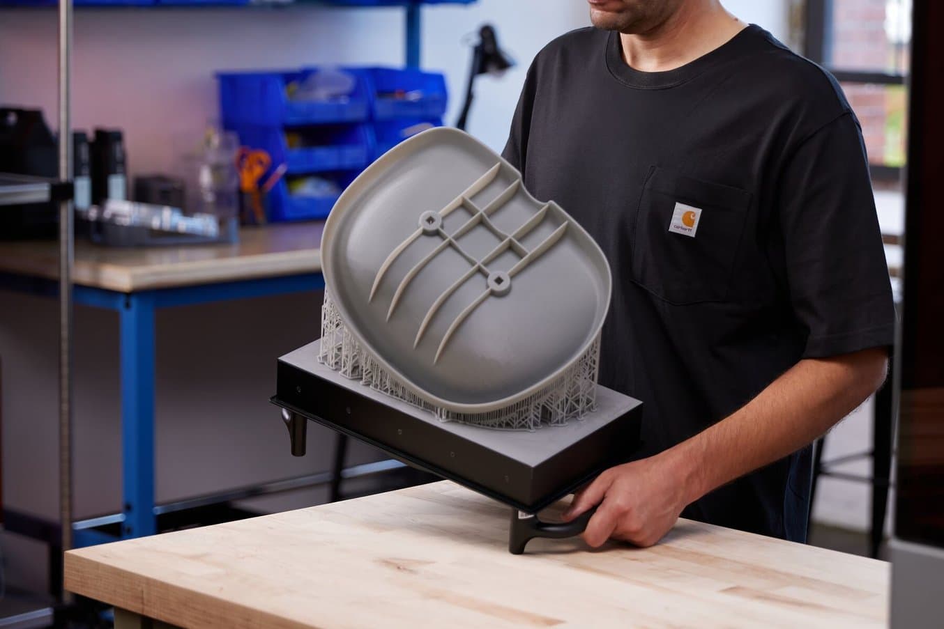 Person holding a grey seat prototype on a Form 4L Build Platform