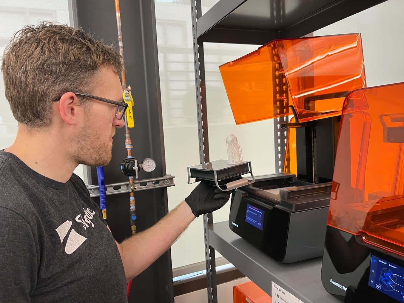 Senior Hardware Development Specialist Eric Weinhoffer unloads a part from one of Skydio's Form 3+ printers