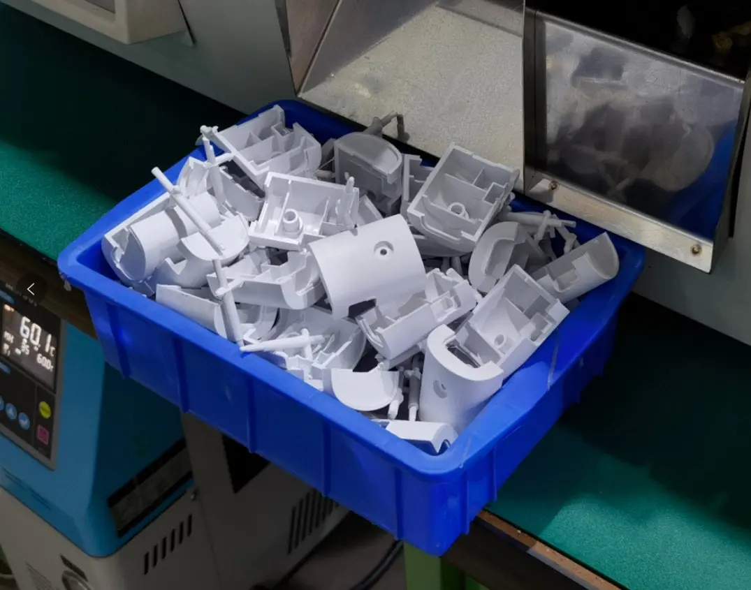 Stampi a iniezione in plastica di colore bianco in una cesta blu