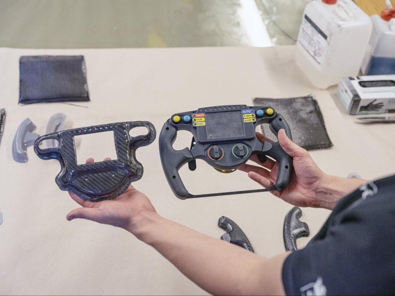A mold (left picture, left hand) used for molding a carbon fiber steering wheel enclosure (left picture, right hand) and a prototype of a complex topology optimized mount (right picture), both printed on a Form 3 SLA 3D printer.