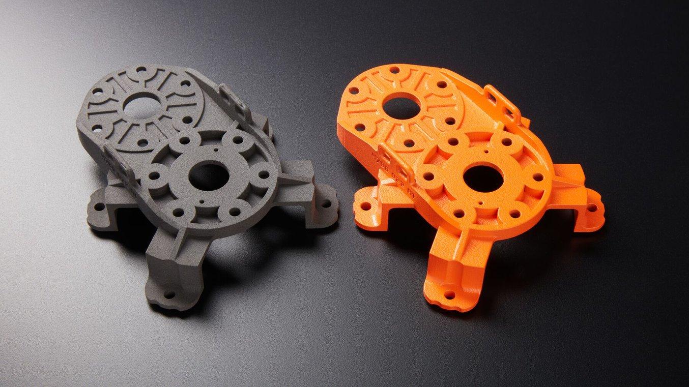 Our test piece, before and after powder coating. The coated part is bright orange and semi-gloss in appearance.