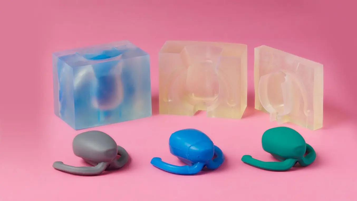 Stampi realizzati in 3D e tre scocche in silicone su sfondo rosa