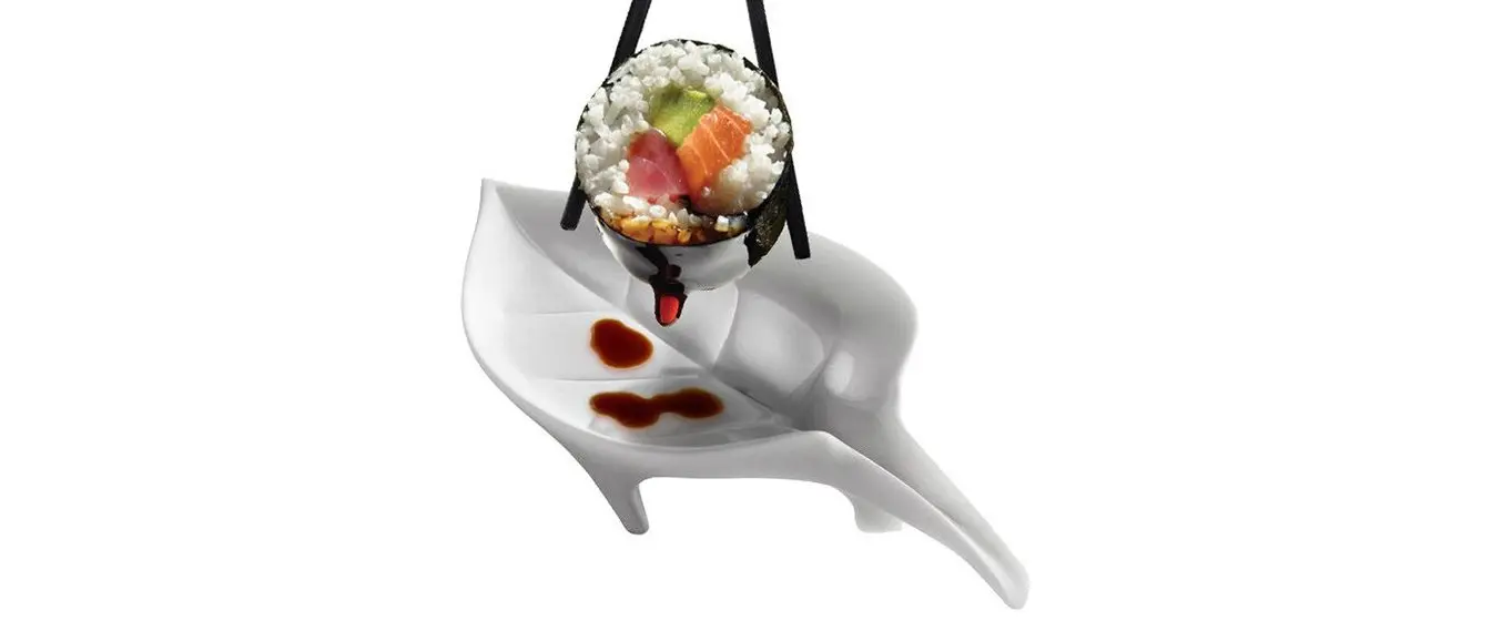 Un sushi roll con della salsa di soia su un piattino a forma di foglia