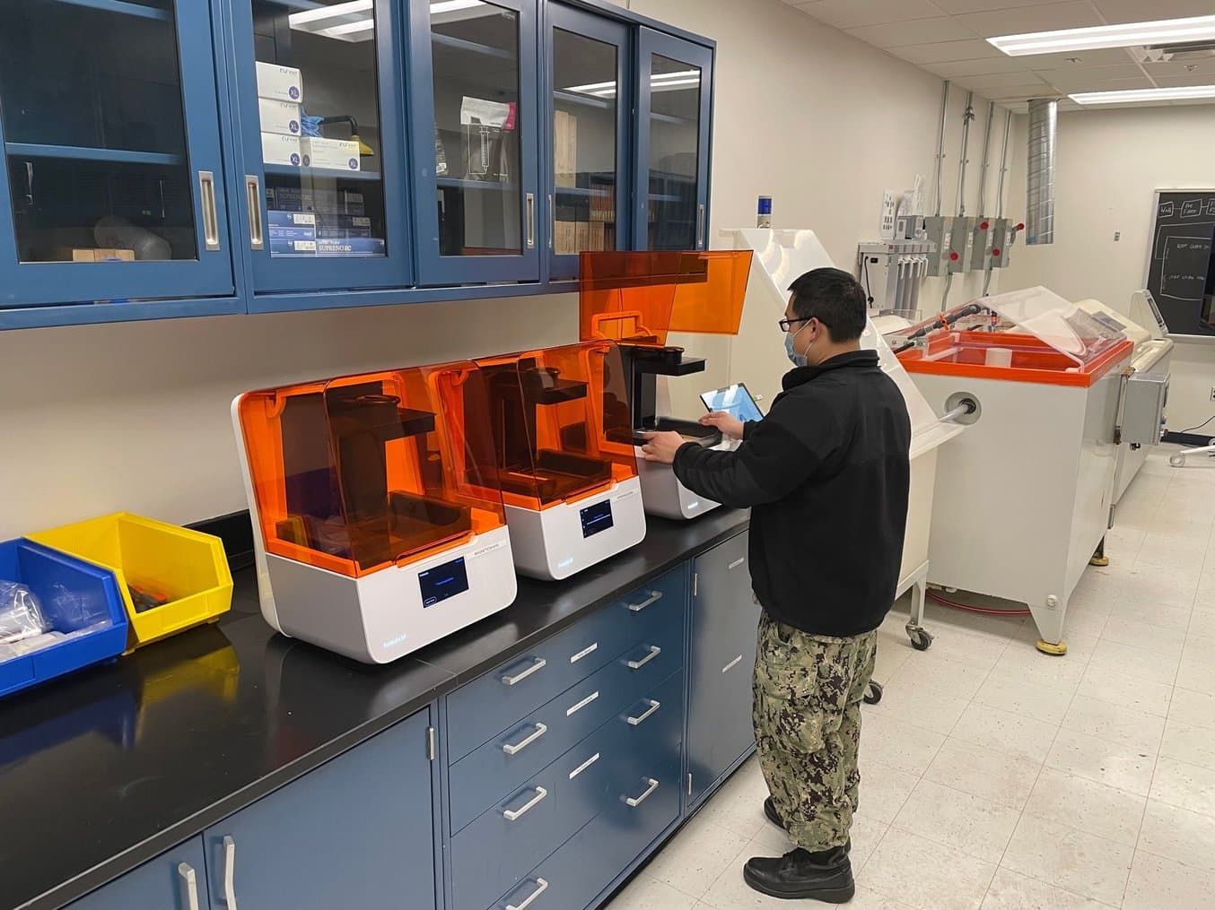 USNA Dental Technician inserting a Resin Tank into the Form 3B printer.