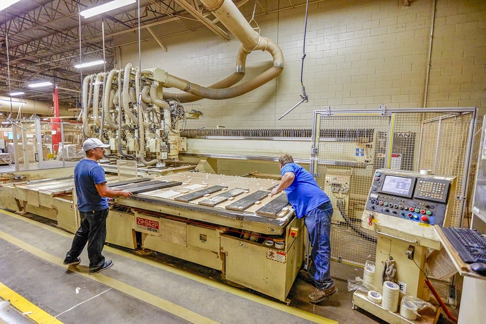 Workers near a CNC router machine