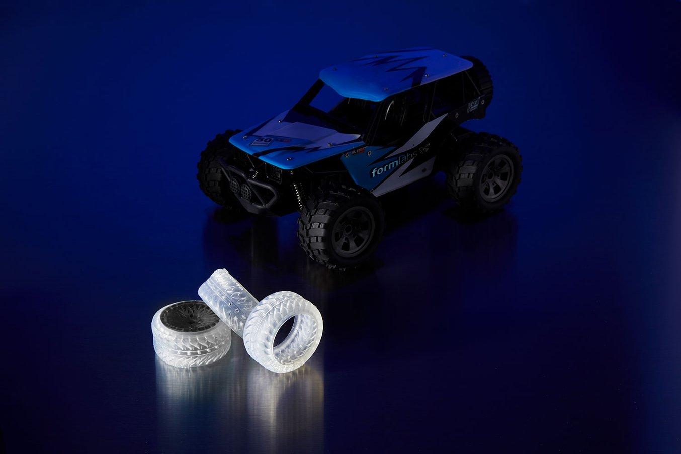 A toy RC car (right), alongside prototype tires printed in Elastic Resin (left).