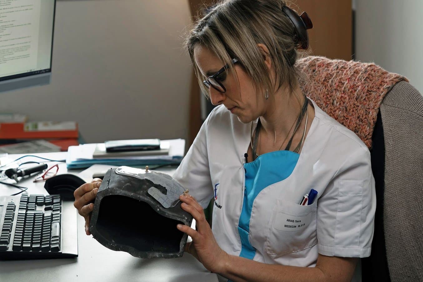 Sara Arias, a doctor for physical and medical rehabilitation holding a compressive face mask.