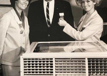 two women and a man stand behind an air conditioning unit in a photo from the 1950s