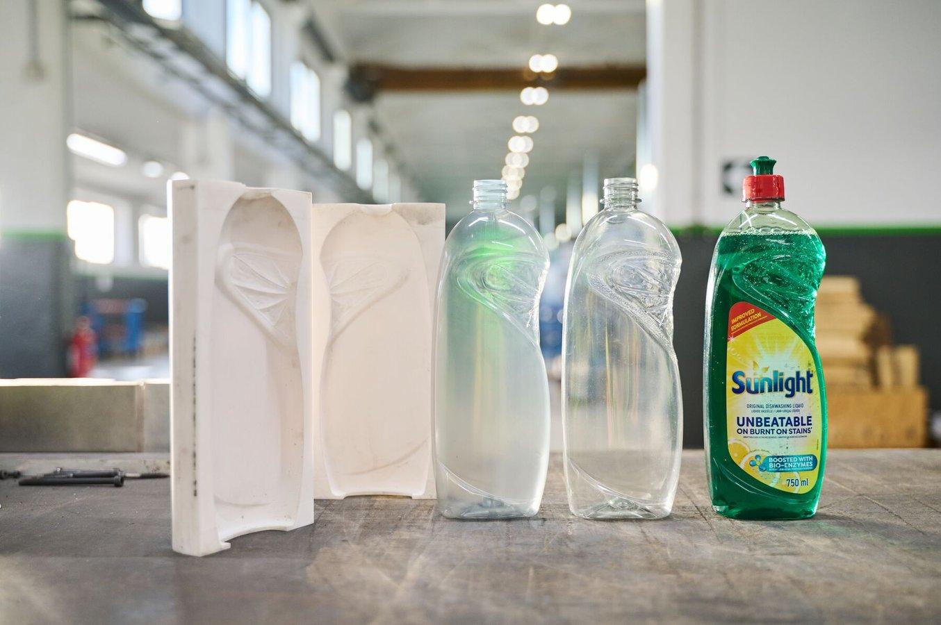 Von links nach rechts: die zweiteilige 3D-gedruckte Form aus Rigid 10K Resin, eine mit der Form aus Rigid 10K Resin produzierte Flasche, eine mit einer Metallform produzierte Flasche und ein etikettierter Prototyp einer Flasche für Verbrauchertests.