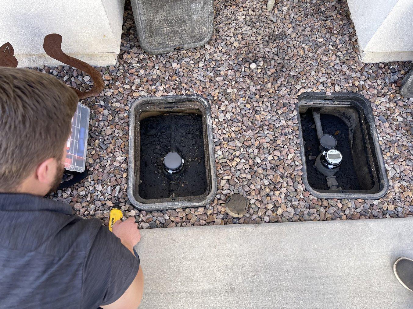 A Next Meters specialist examines a water meter to be fitted with a 3D printed bracket.