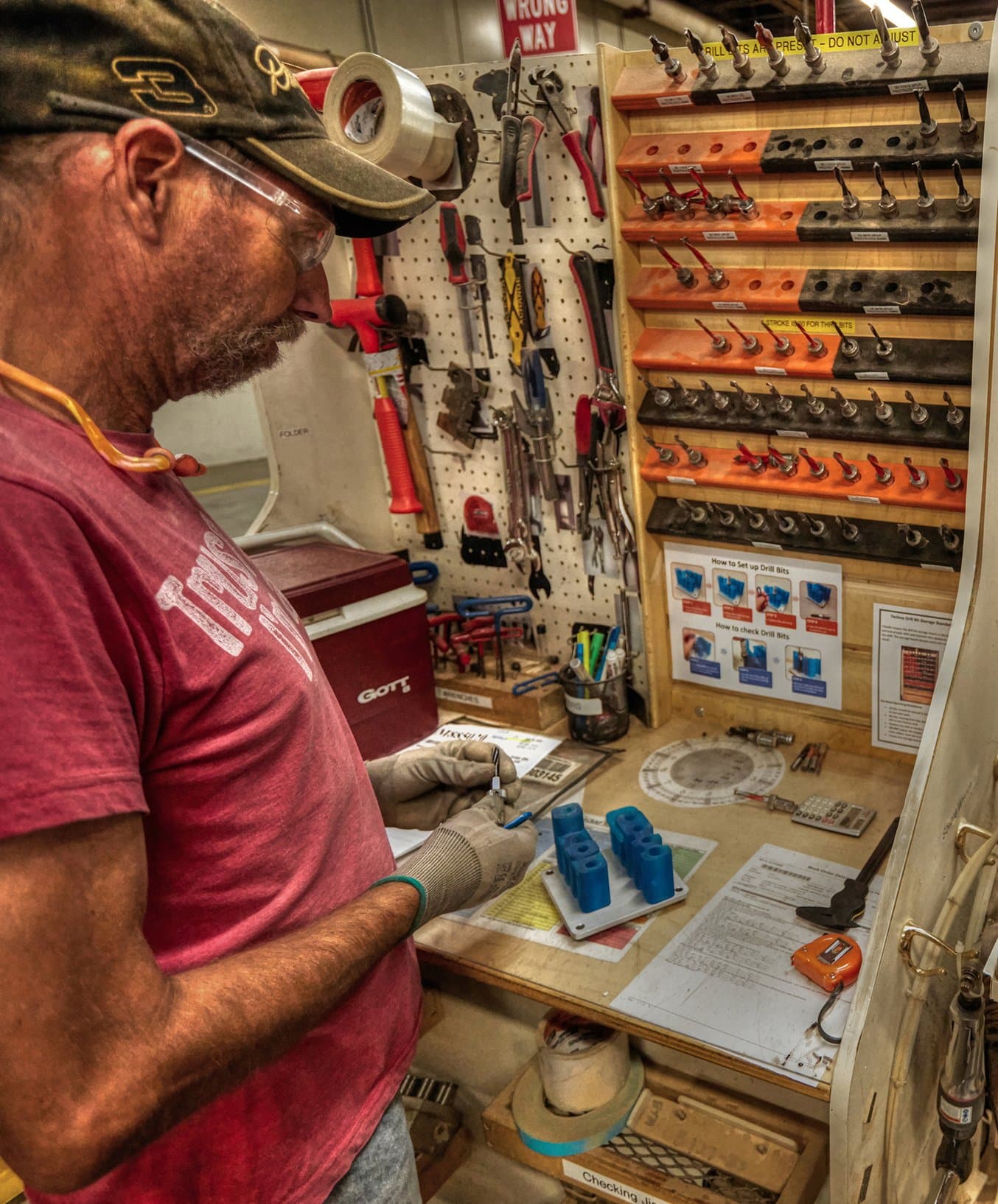 A worker uses a 3d printed drill bit guide