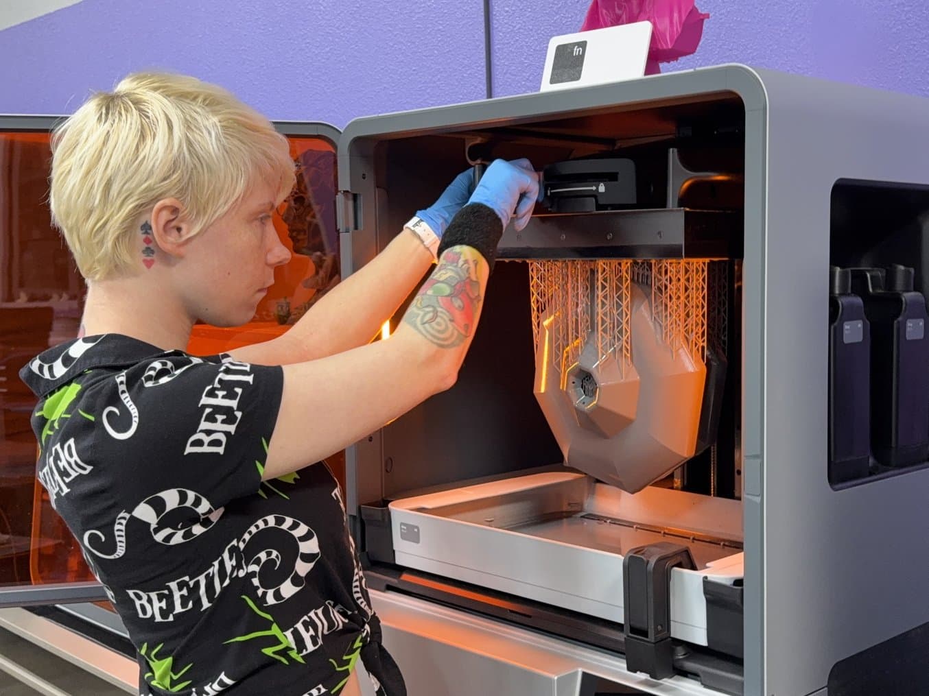 Person wearing gloves and removing a build platform from Form 4L