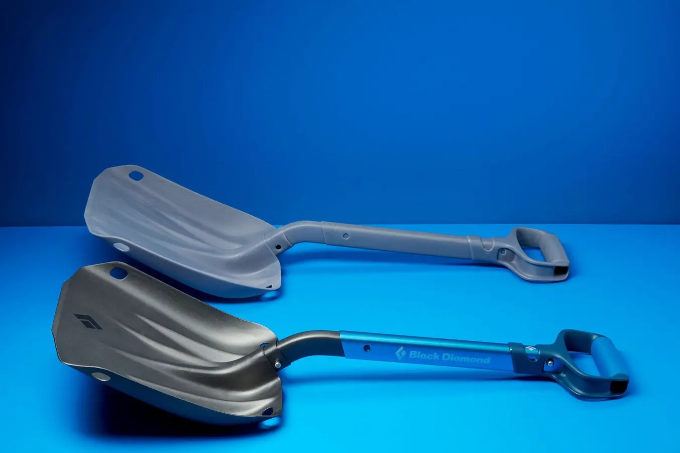 a prototype of a Black Diamond shovel on a blue background next to the real end-use manufactured shovel
