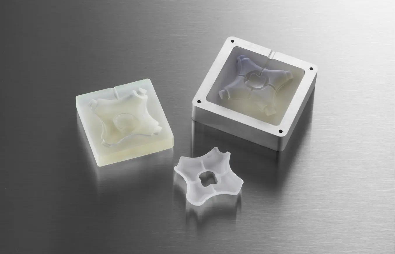 Uno stampo prodotto in 3D con Formlabs e un componente incapsulato realizzato tramite questo processo di stampaggio a iniezione fai da te.