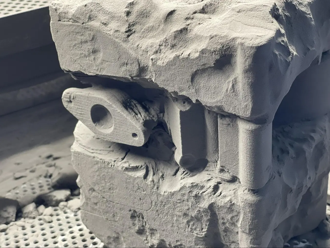 An SLS 3D printed component during post-processing with the Fuse Sift.