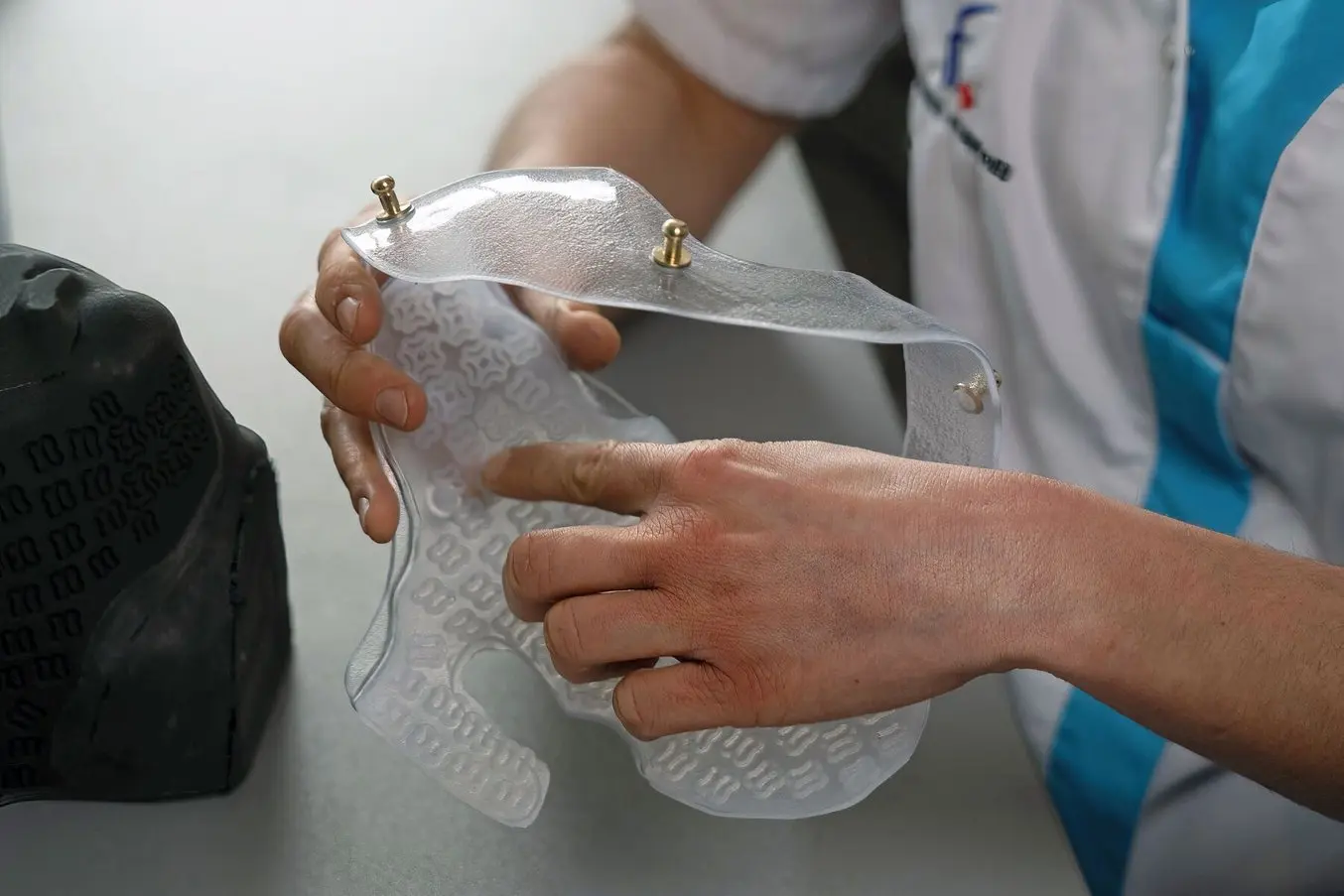 Sara Arias, a doctor for physical and medical rehabilitation holding a compressive face mask.