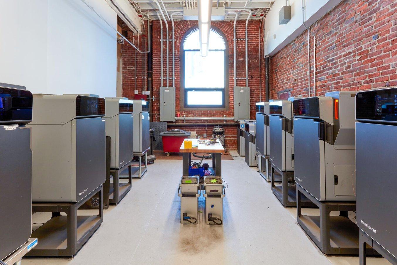 A print farm production setting with multiple Fuse 1 3D printers and Fuse Sift post processing machines.
