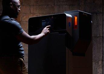 a man stands in front of the Formlabs Fuse 1+ 30W printer