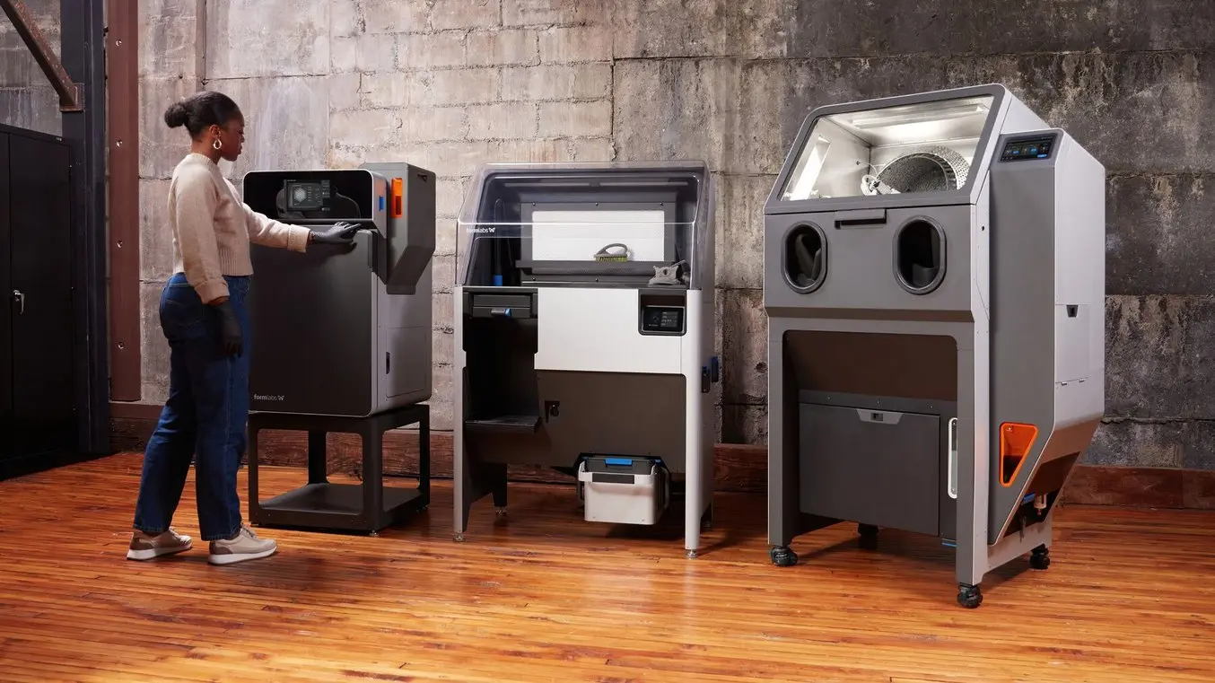 a woman presses a button on the fuse series SLS 3d printer