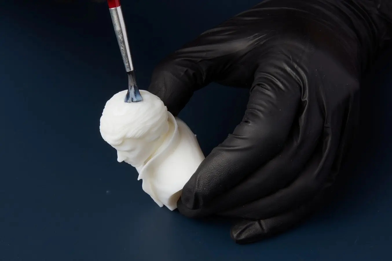 Priming a 3D printed miniature before painting.